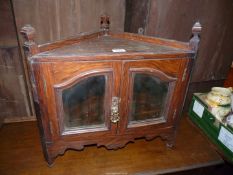 A small Oak Corner Cabinet having shaped bevelled mirrors to the opposing doors,