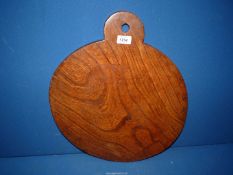 A Welsh chopping board of Elm wood, 17 1/2" diameter, slightly warped.