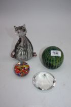 A small quantity of glass paperweights including blue and green Mdina, purple and white stripe cat,