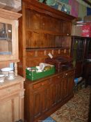 A medium Oak Dresser, the base with three double panel doors with three fireze drawers over,