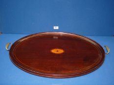 A 19th century Mahogany and satinwood oval butlers tray with brass handles, 26" long.