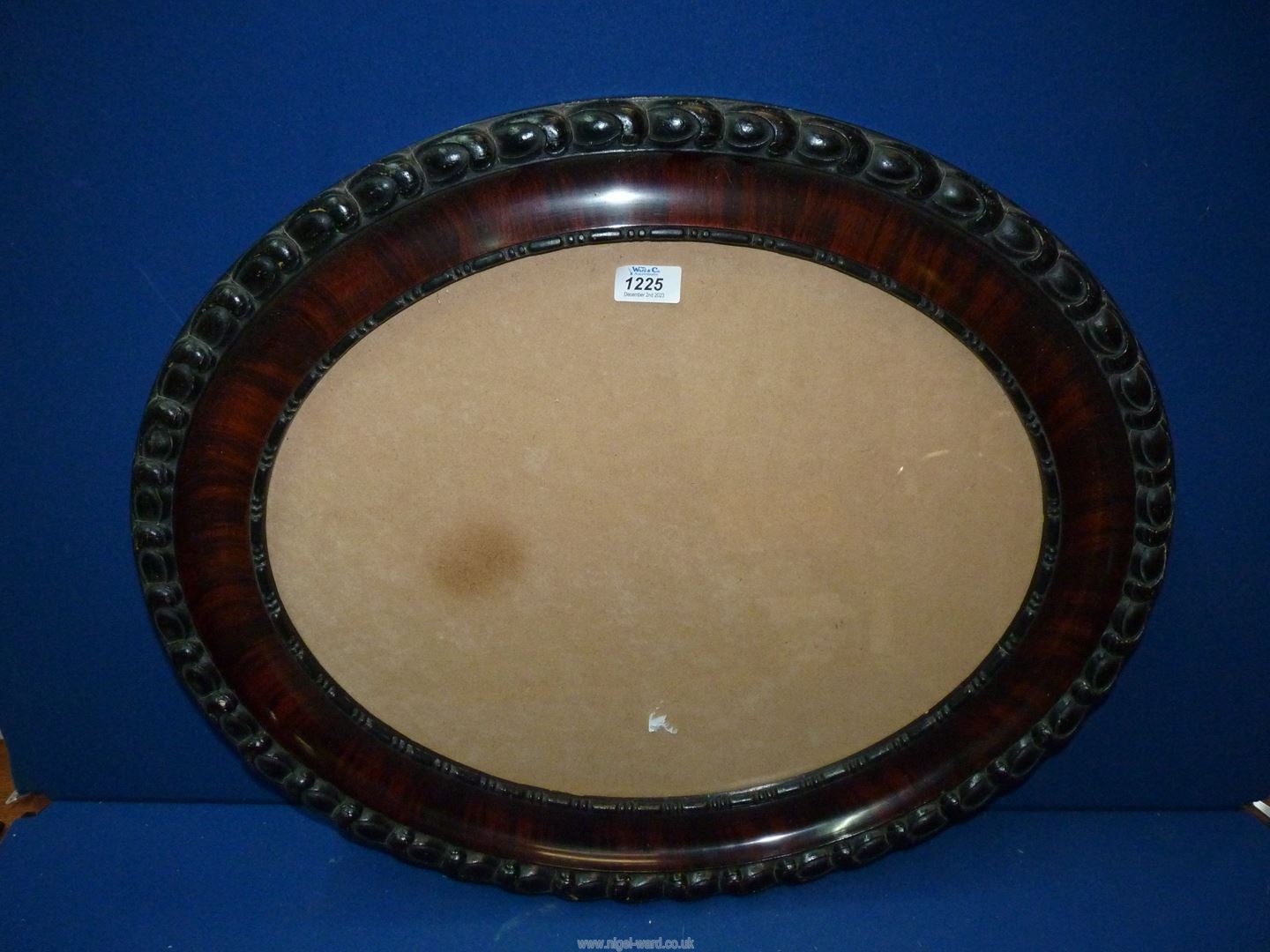 A dark wood oval glazed frame, aperture 19" x 16".