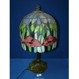 A Tiffany style table lamp , the shade having red poppy design on a base with daffodil decoration,