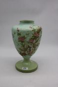 A green milk glass hand painted vase with flowers.