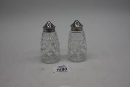 A pair of Waterford slice cut crystal peppers having metal lids and bases, stamped, 5" tall.