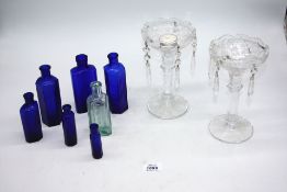 Six cobalt blue 'Poison' bottles, pale green lung tonic bottle and two plain candle lustres.