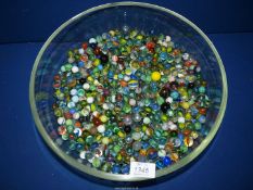 A large quantity of marbles in a wide shallow bowl.