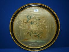 A circular framed embroidery of flowers in a basket (marked) 19" diameter including frame.