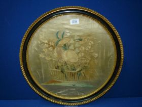 A circular framed embroidery of flowers in a basket (marked) 19" diameter including frame.