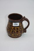 A vintage brown ceramic slip ware Frog beer mug inscribed 'Beer is Best' with hidden frog,