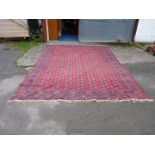 A large carpet in red and blue geometric design. 173" x 121".