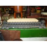 A heavy black cast metal fire kerb with elaborate shell and scroll style decoration,