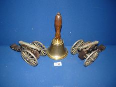 A pair of model Cannons on wooden mounts (one a/f), 8 1/2" long and a brass hand bell.