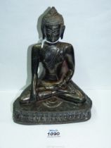 A large antique bronze model of a religious deity sitting cross legged, 8" tall.