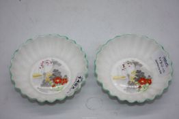 Two Shelley dessert bowls having green rims decorated with garden scenes.