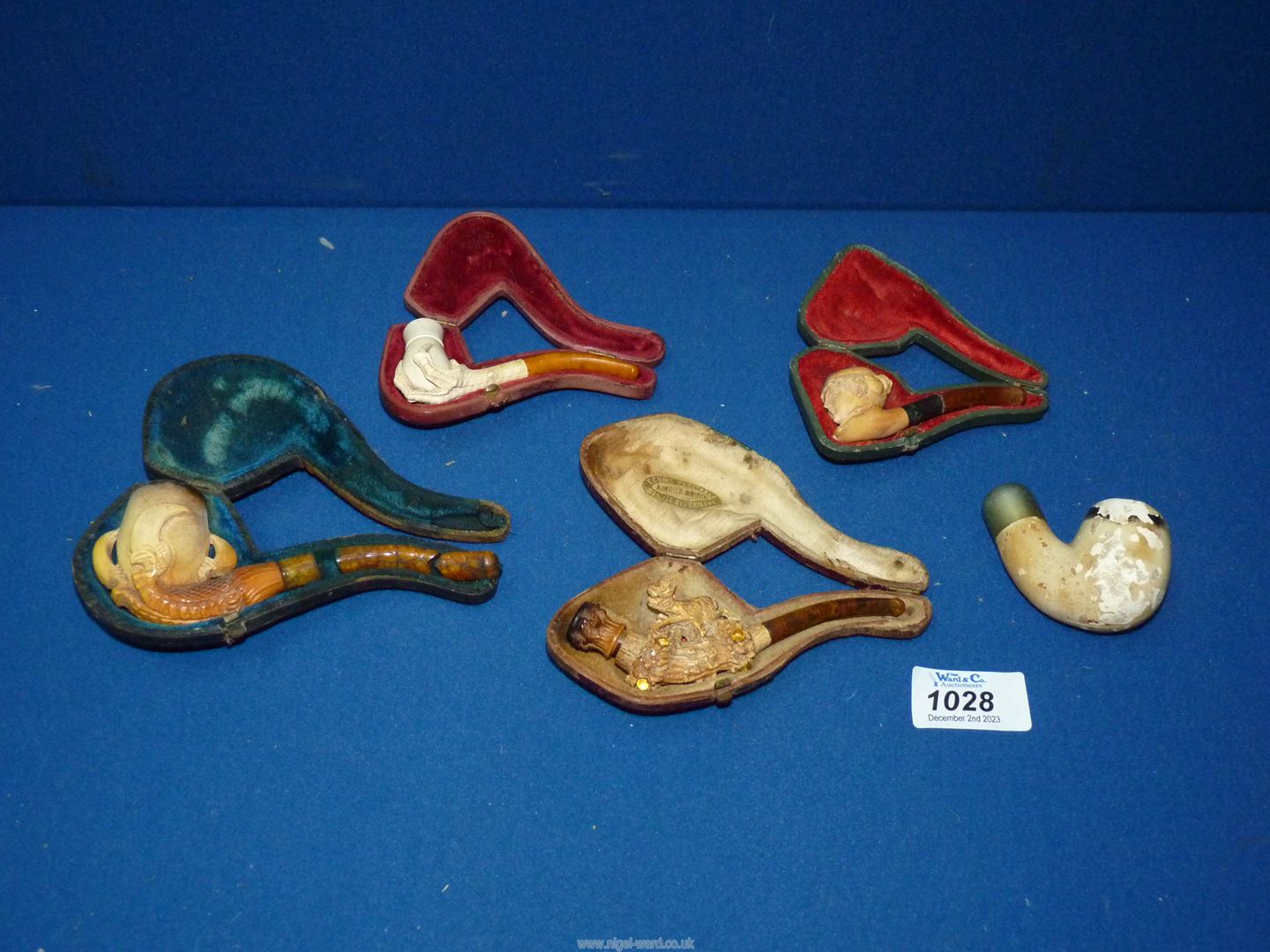 A small tray containing four carved meerschaum pipes/cheroot holders to include; stag, maiden,
