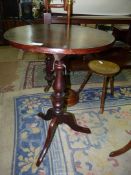 A mixed woods circular occasional Table standing on a turned pillar with three splay feet,