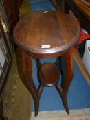 An Oak oval occasional Table standing on shaped legs united by a lower shelf,