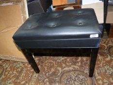 A contemporary black/ebony coloured piano stool,