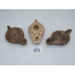 Three ancient Roman terracotta oil lamps.