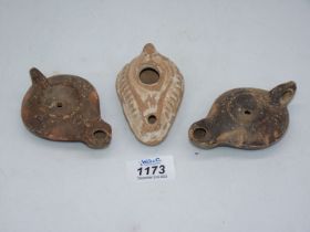 Three ancient Roman terracotta oil lamps.