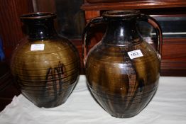Two Studio Pottery vases, one with handles in black, russet and olive green drip glaze,