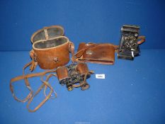 A leather cased pair of R.J. Binoculars, (one eye piece missing) and a cased Kodak camera.