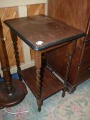 A rectangular Oak occasional Table standing on twist legs united by a lower shelf (top repaired),