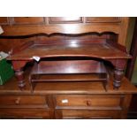 A Satinwood bed Tray raised on turned legs and a Mahogany/Walnut bookrack.