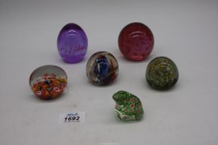 A quantity of Paperweights to include cranberry with bubbles, etc.