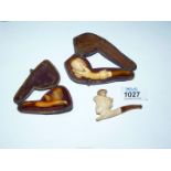 A small box containing three tiny carved Meerschaum cheroot holders, one depicting an acorn,