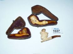 A small box containing three tiny carved Meerschaum cheroot holders, one depicting an acorn,