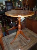 A cross-banded topped circular occasional Table standing on a turned pillar with three splay feet,