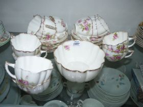 A rose patterned part Teaset including; twelve cups & saucers and a slop bowl.