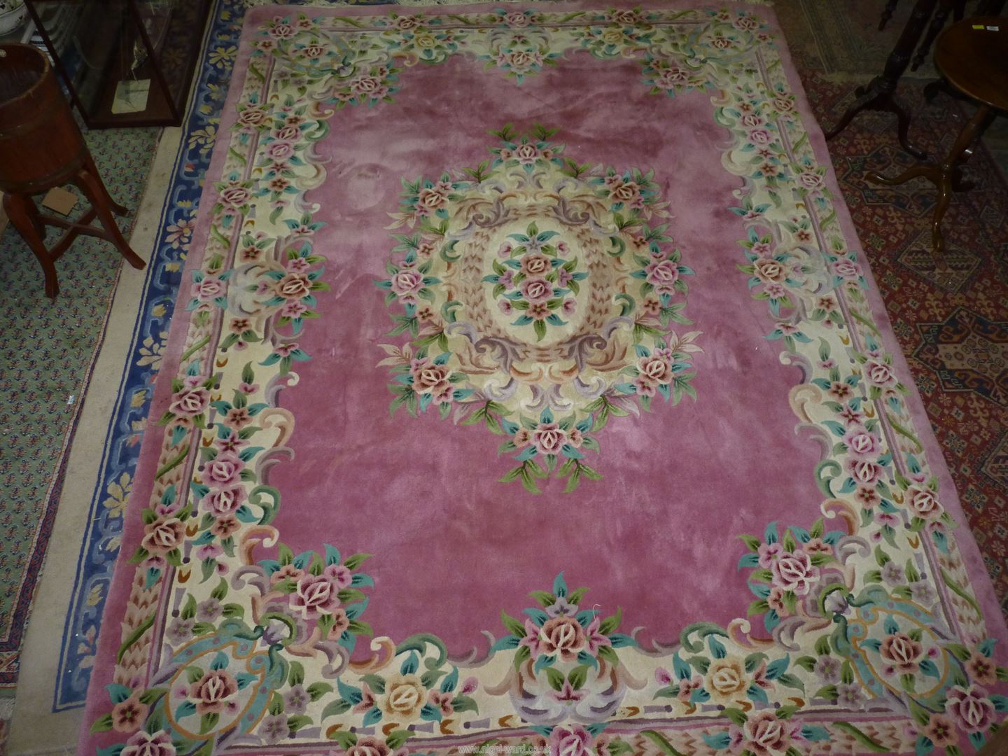 A large pink Chinese carpet, 140" long x 103 1/2'' wide.