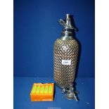 A circa 1930's Soda Syphon with metal grill and a box of Sparklets cylinders.