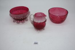 Two cranberry glass bowls; one with matching jug.