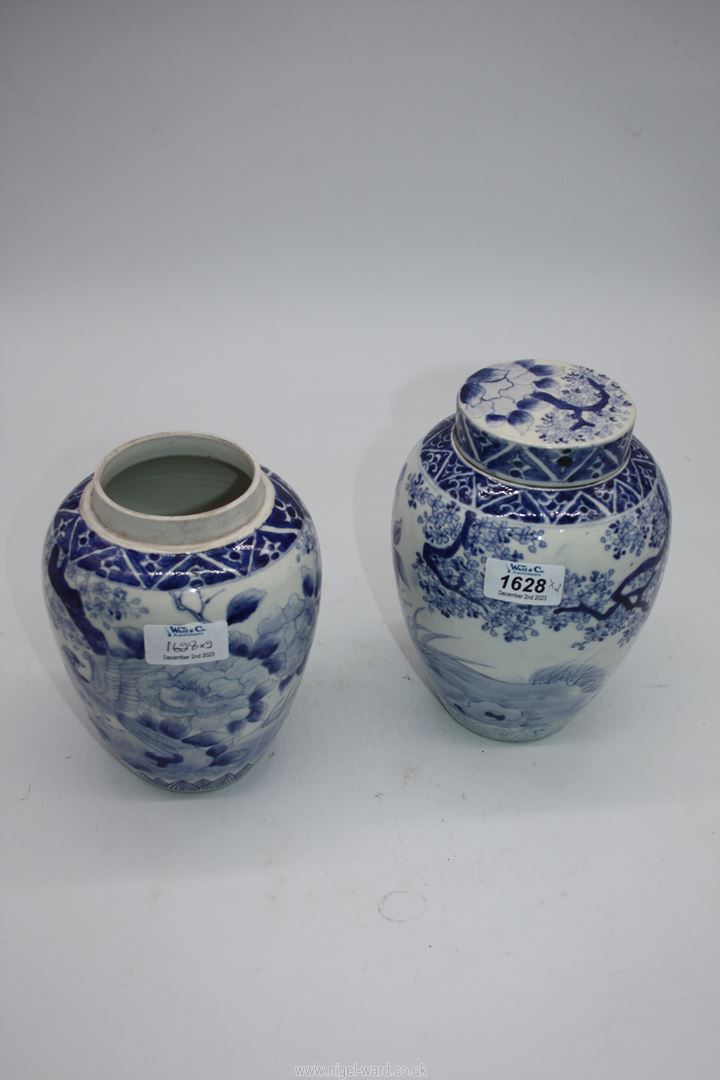 A pair of hand painted blue and white oriental ginger jars, one lid missing, 19cm tall.