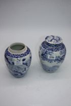 A pair of hand painted blue and white oriental ginger jars, one lid missing, 19cm tall.