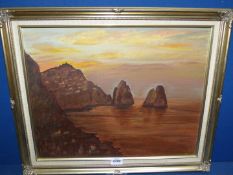 A framed oil on board of a rocky coastal scene at sunset, signed lower right M.