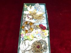 A quantity of brooches including Staffordshire flower clusters, poppy, etc.