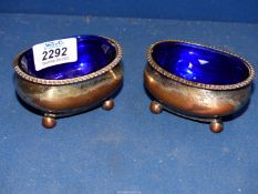 A pair of silver plated Salts with blue glass liners.