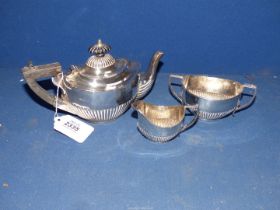 A three piece Silver Teaset in half ribbed pattern, ebonised handle and finial to teapot,