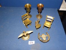A quantity of brass including brass chairs, two goblets, a Wales door knocker and bird lid finial.