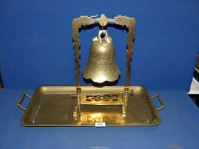 A hanging brass bell on stand with hammer, decorated with dragons, together with a brass tray.