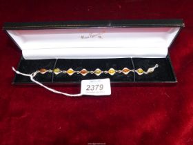 A silver bracelet set with nine amber beads in three different colours, Birmingham 925, makers PW,