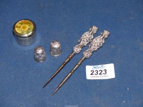 Two silver handled stilletos, two silver thimbles and silver pill box with floral insert to the lid,