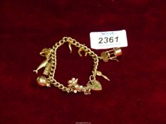 A 9ct gold Charm bracelet with hallmarked gold charms including wishbone, dart, teddy bear, etc.