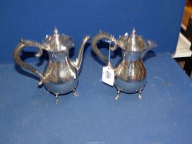 A Silver coffee Pot and hot water pot, with ebonised handles, standing on paw feet, Sheffield 1912,