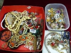 A quantity of costume jewellery to include; beads, chains, brooches, etc.